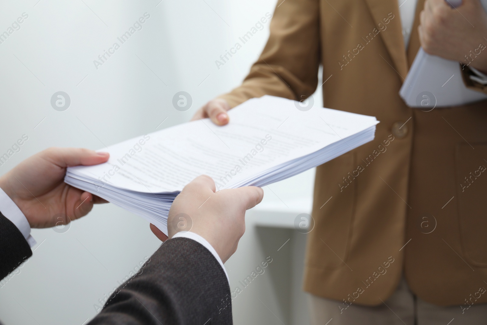 Photo of Woman giving many documents to man in office, closeup