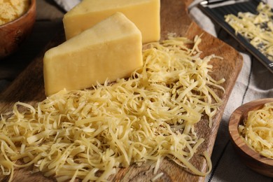 Photo of Grated and whole pieces of cheese on table, closeup