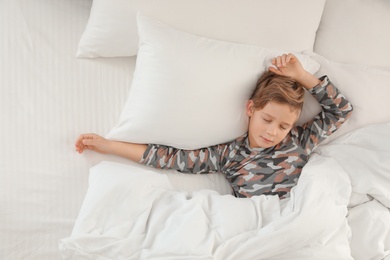 Photo of Cute boy sleeping in bed, above view