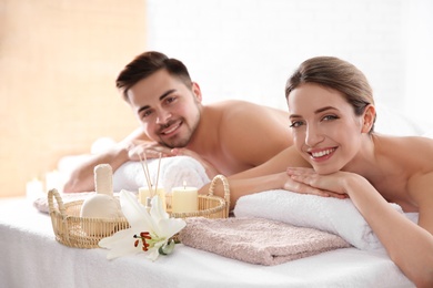 Photo of Young couple with spa essentials in wellness center