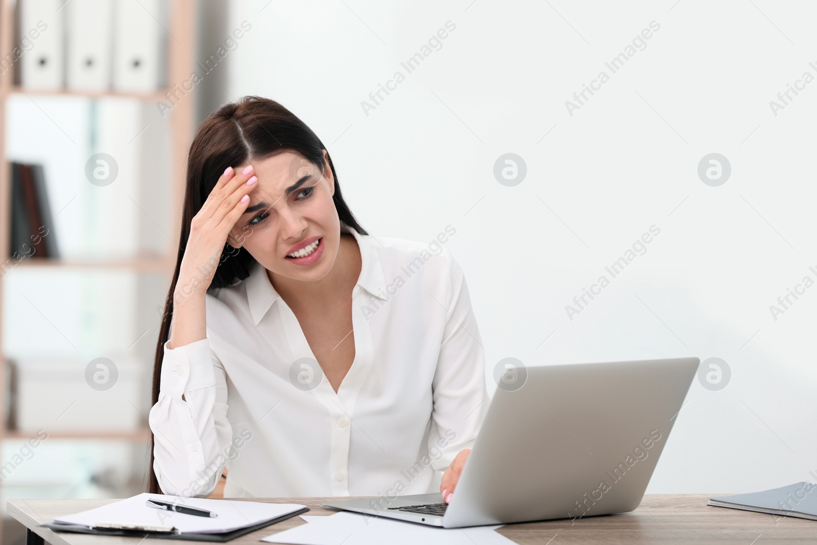 Photo of Woman suffering from migraine at workplace in office, space for text