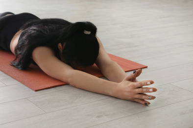 Photo of Young woman practicing relaxation pose in yoga studio, closeup