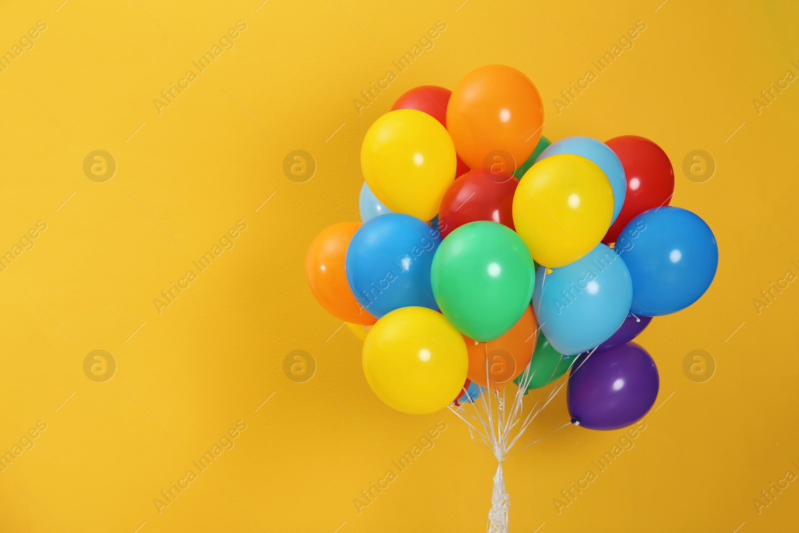 Photo of Bunch of bright balloons and space for text against color background