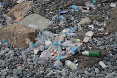 Garbage scattered on pebbles outdoors. Recycling problem