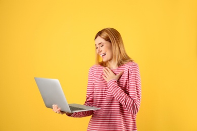 Photo of Woman using laptop for video chat on color background