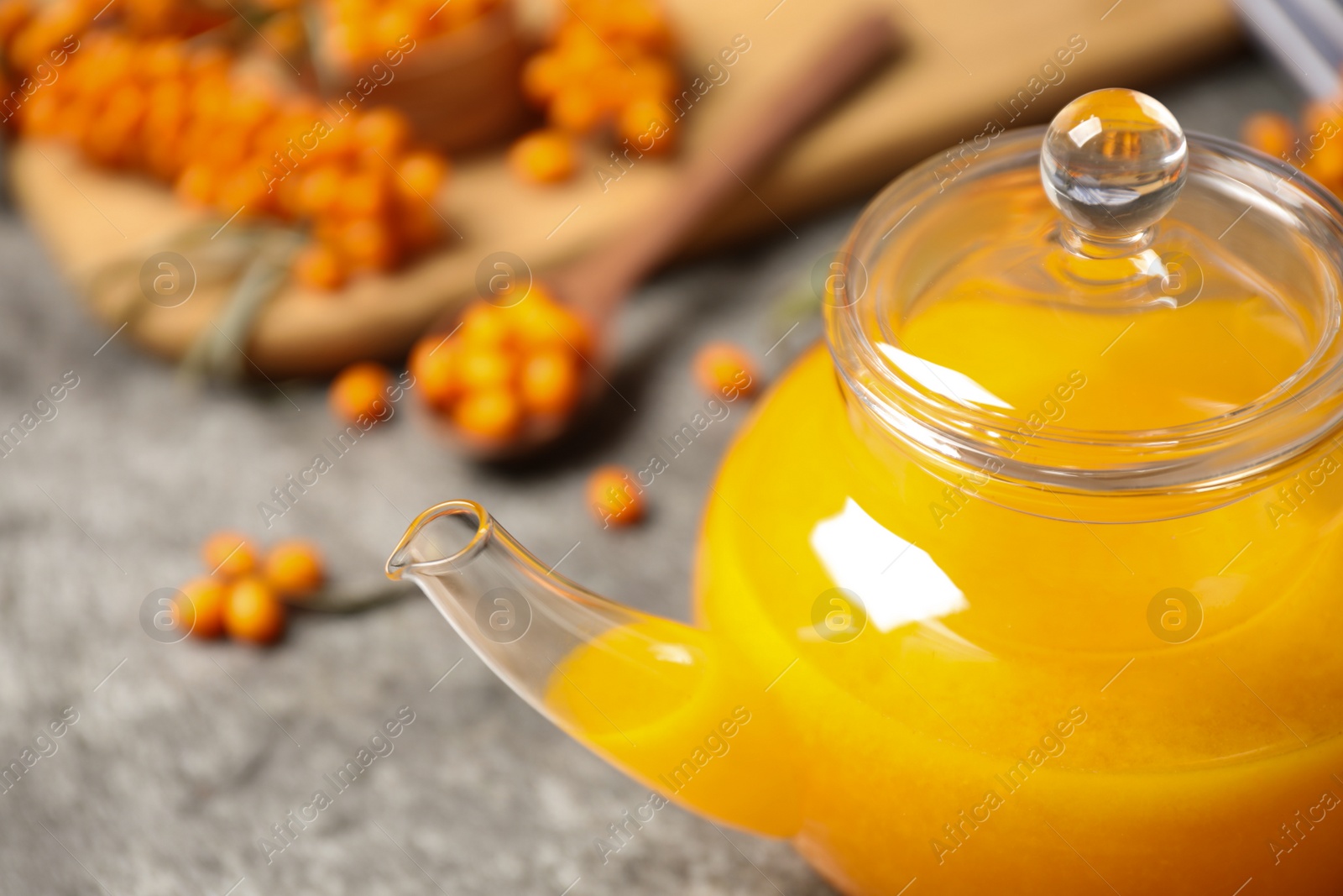 Photo of Delicious sea buckthorn tea in teapot, closeup