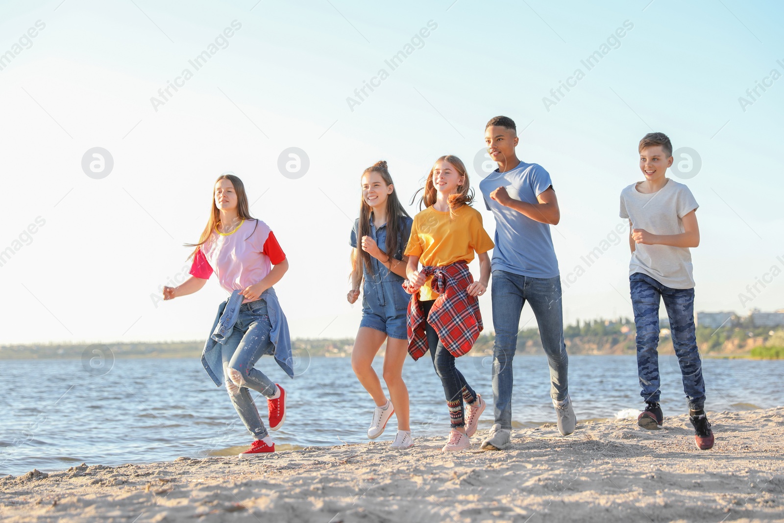 Photo of Group of children running on beach. Summer camp