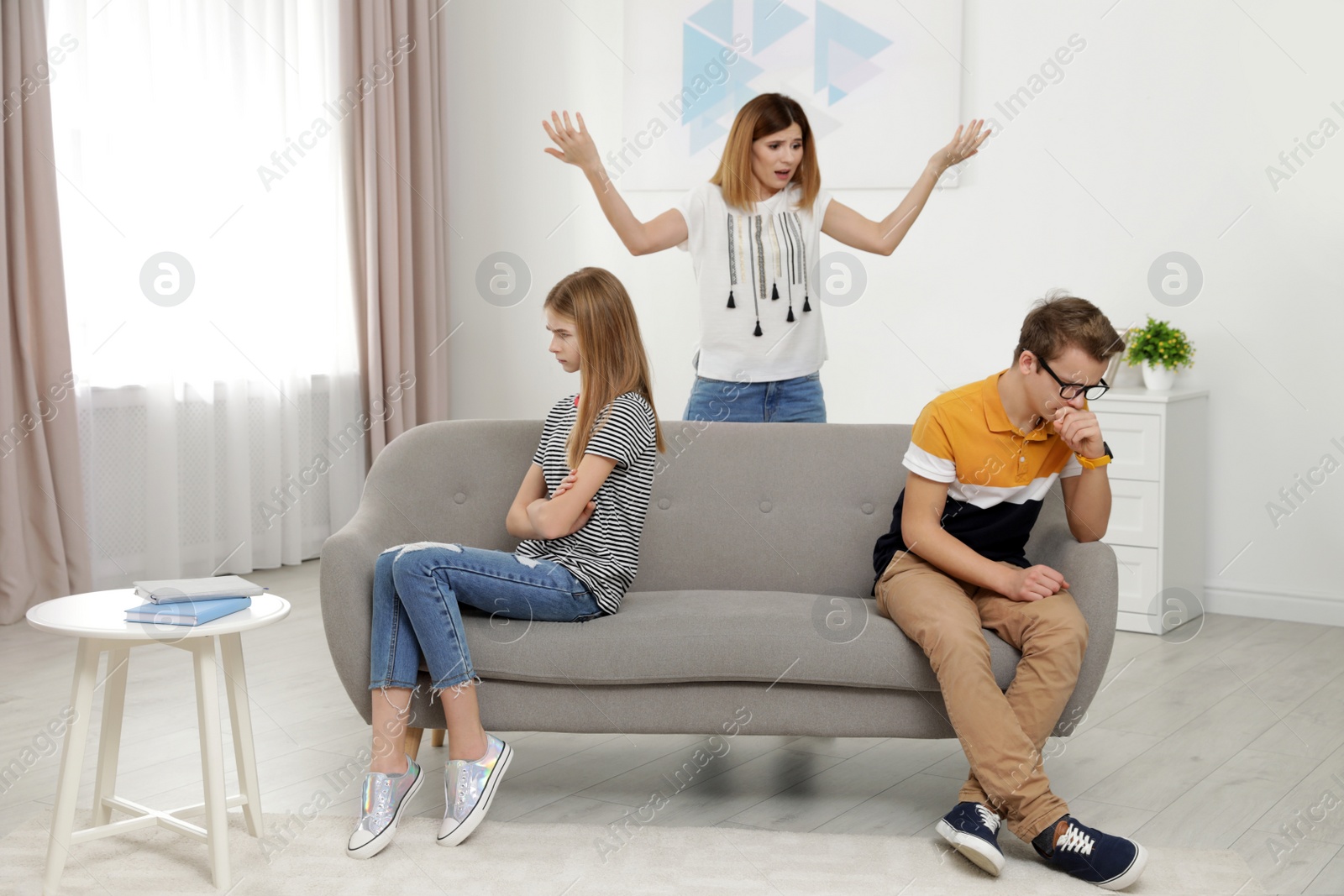 Photo of Mother scolding her teenager daughter and son at home