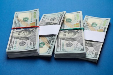 Photo of Many dollar banknotes on blue background. American national currency