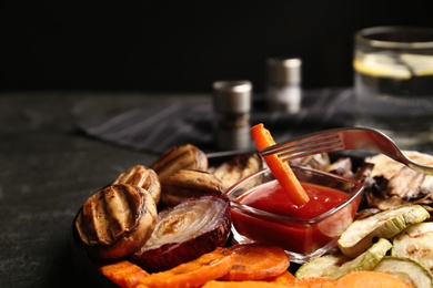 Delicious grilled vegetables and mushrooms served on grey table, closeup