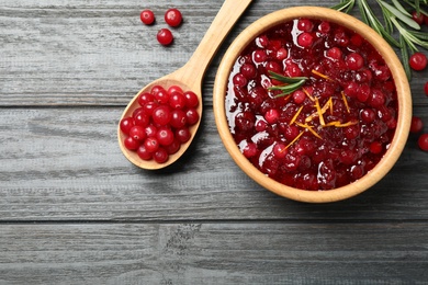 Flat lay composition with cranberry sauce on grey wooden table, space for text