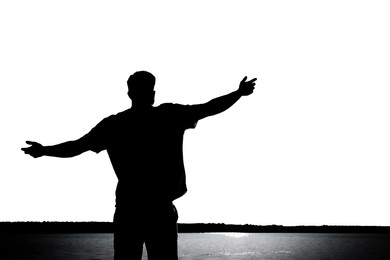 Silhouette of man near river, back view