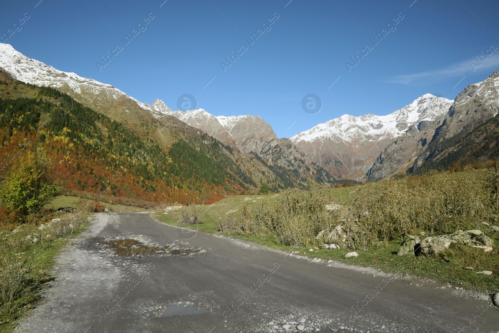 Photo of Picturesque view of empty gravel road in mountains on sunny day