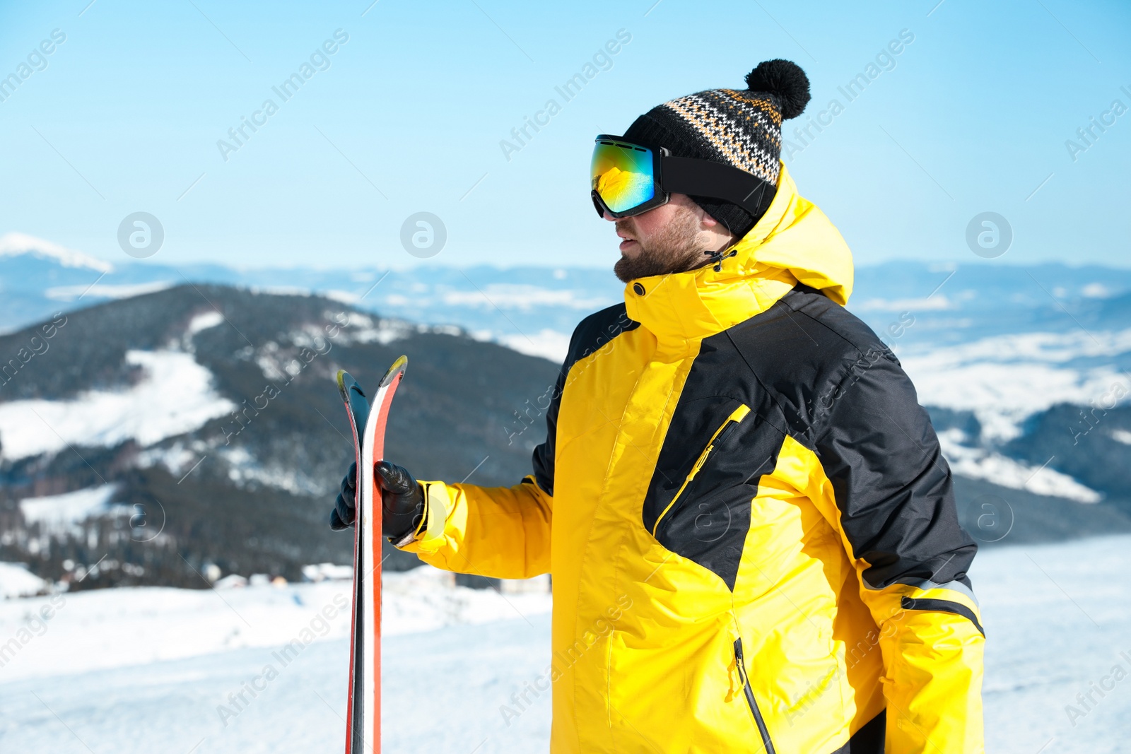 Photo of Happy man with ski equipment in mountains. Winter vacation