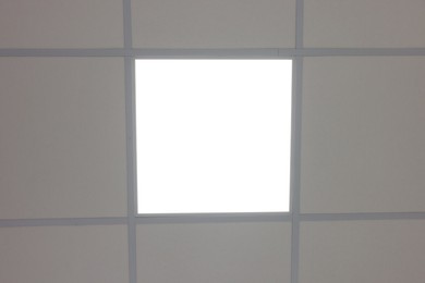 Photo of White ceiling with PVC tiles and lighting, bottom view