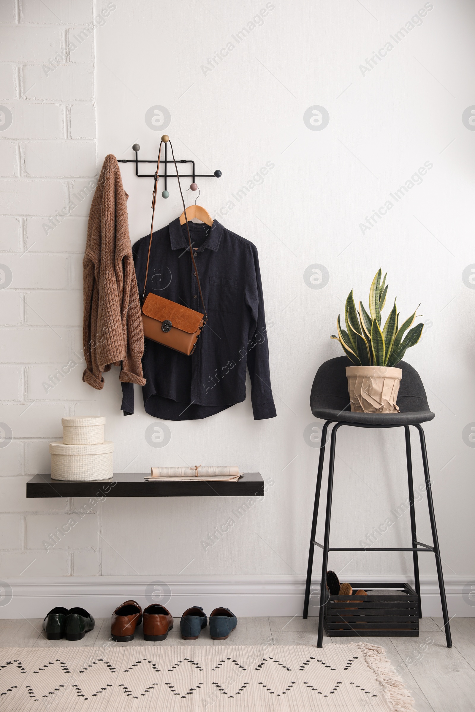 Photo of Hallway interior with stylish furniture, clothes and accessories