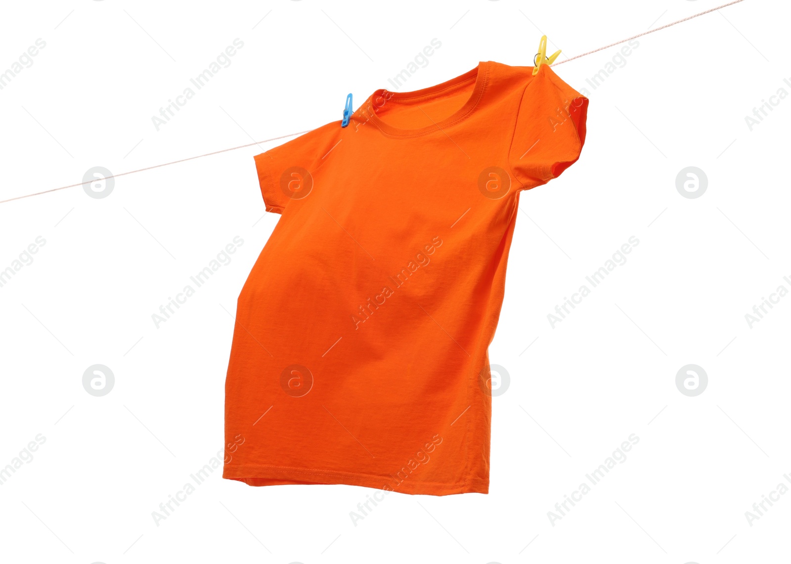 Photo of One orange t-shirt drying on washing line isolated on white