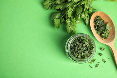 Flat lay composition with fresh and dried parsley on green background. Space for text