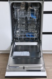 Open clean empty dishwasher in kitchen. Home appliance