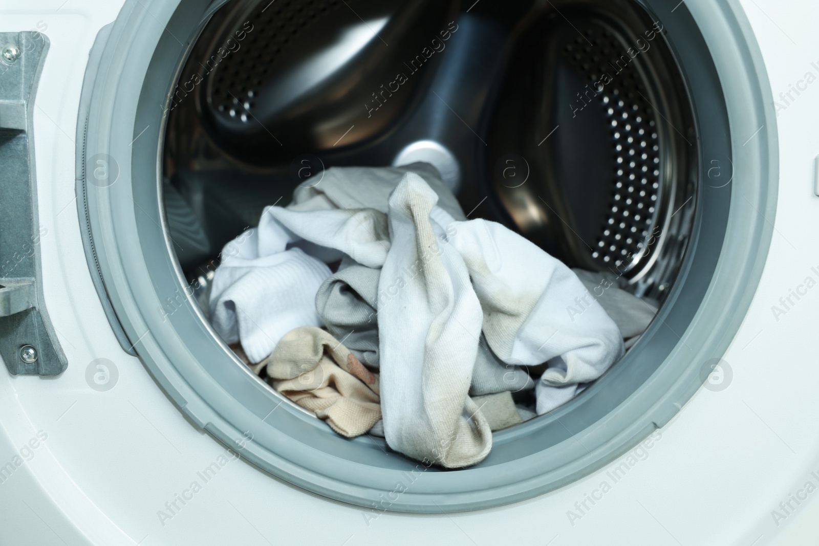 Photo of Many dirty socks in washing machine, closeup