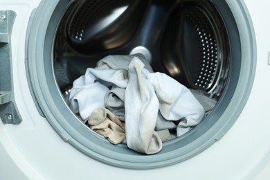 Photo of Many dirty socks in washing machine, closeup
