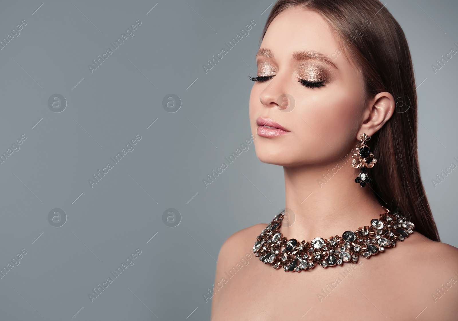 Photo of Beautiful woman with stylish jewelry on grey background, space for text