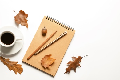 Photo of Flat lay composition with notebook, cup of coffee and autumn leaves on white background. Space for text