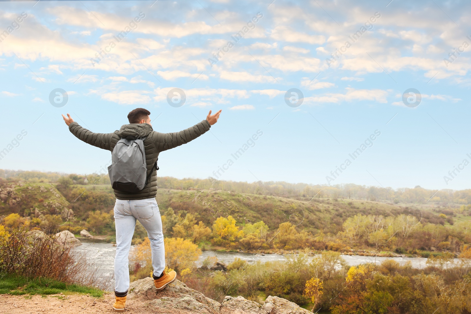 Photo of Traveler with backpack enjoying beautiful view on sunny day. Autumn vacation