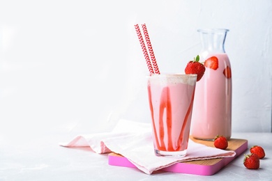 Glassware with delicious milk shakes on white background