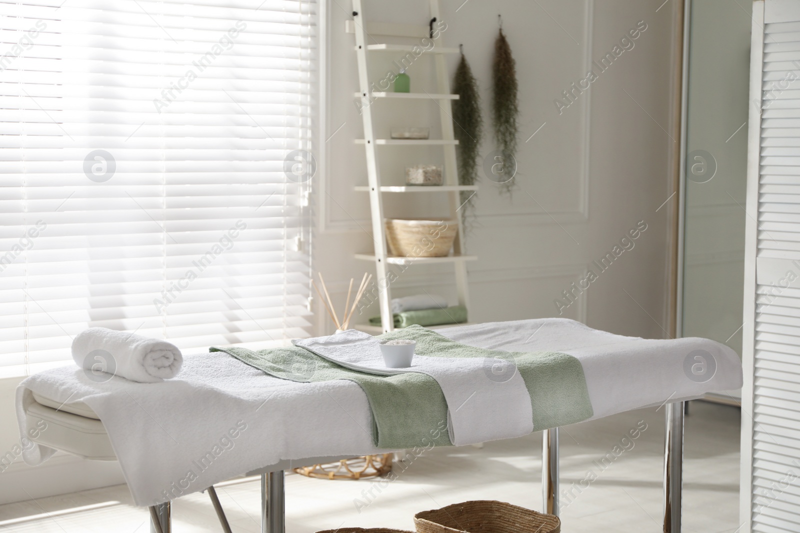 Photo of Stylish spa salon interior with massage table