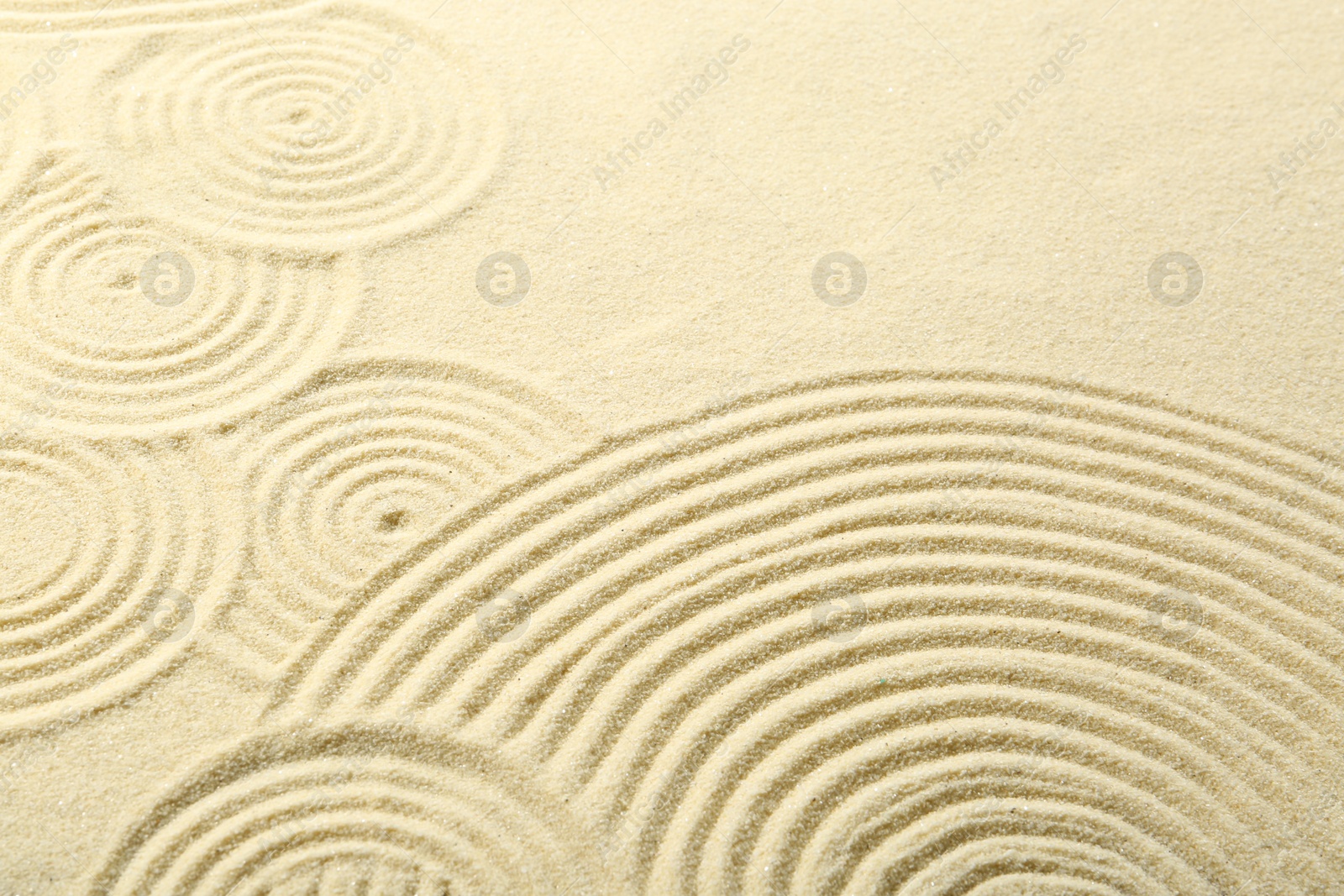 Photo of Zen rock garden. Circle patterns on beige sand