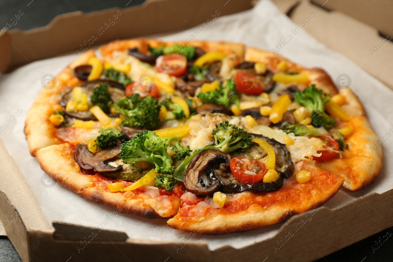 Photo of Delicious vegetarian pizza with mushrooms, cheese and vegetables in box on table, closeup