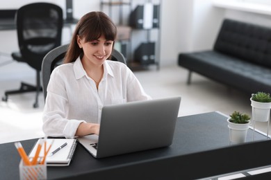 Woman watching webinar at table in office