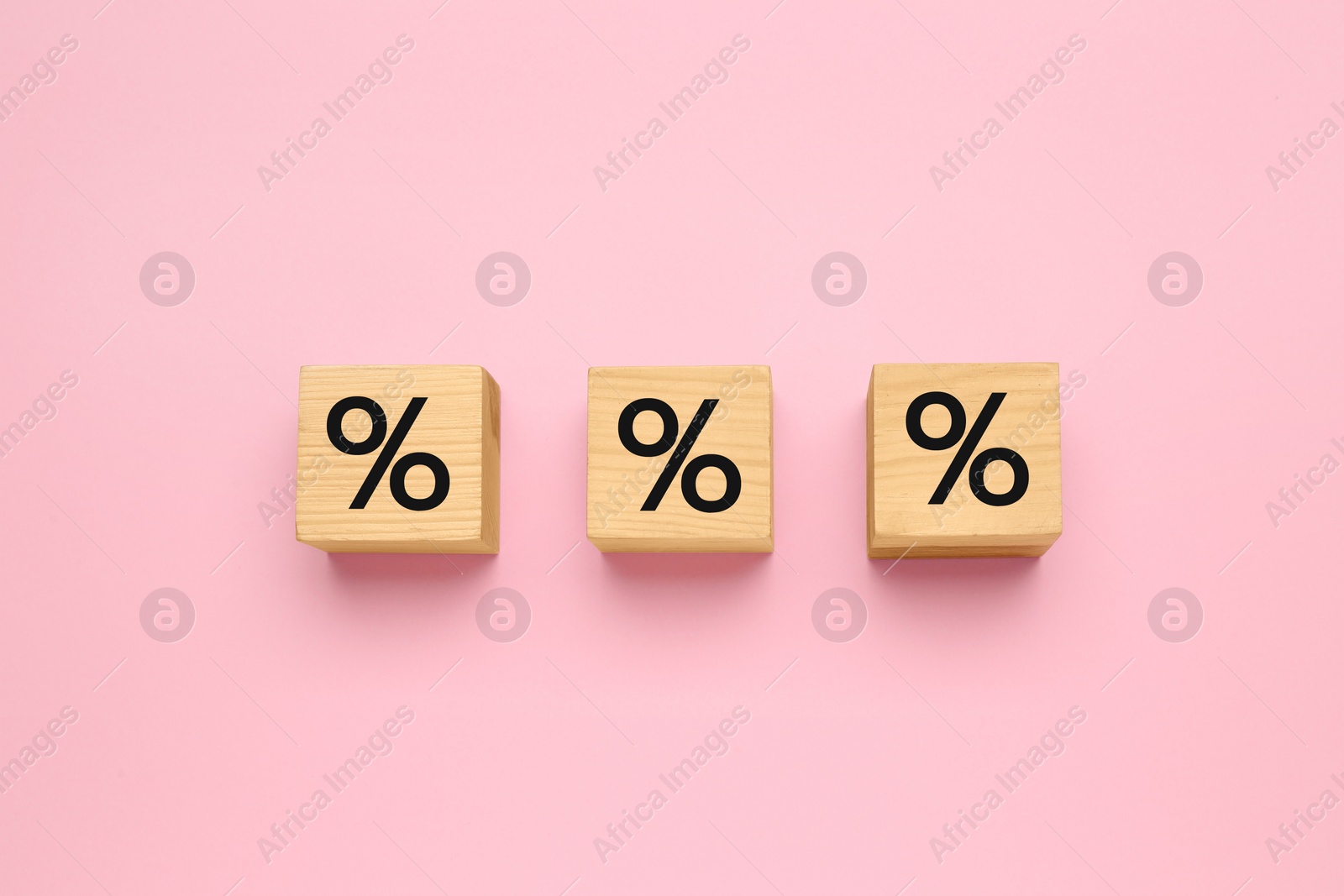 Photo of Wooden cubes with percent signs on pink background, flat lay