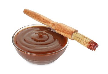 Photo of Tasty barbecue sauce in bowl and brush isolated on white