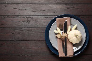 Photo of Autumn table setting on wooden background, top view. Space for text