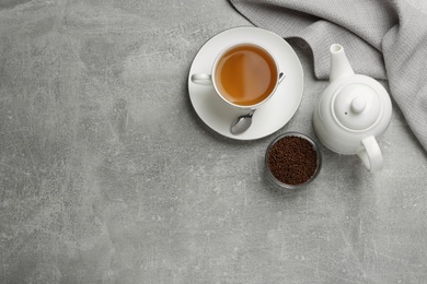 Photo of Buckwheat tea and granules on grey table, flat lay. Space for text