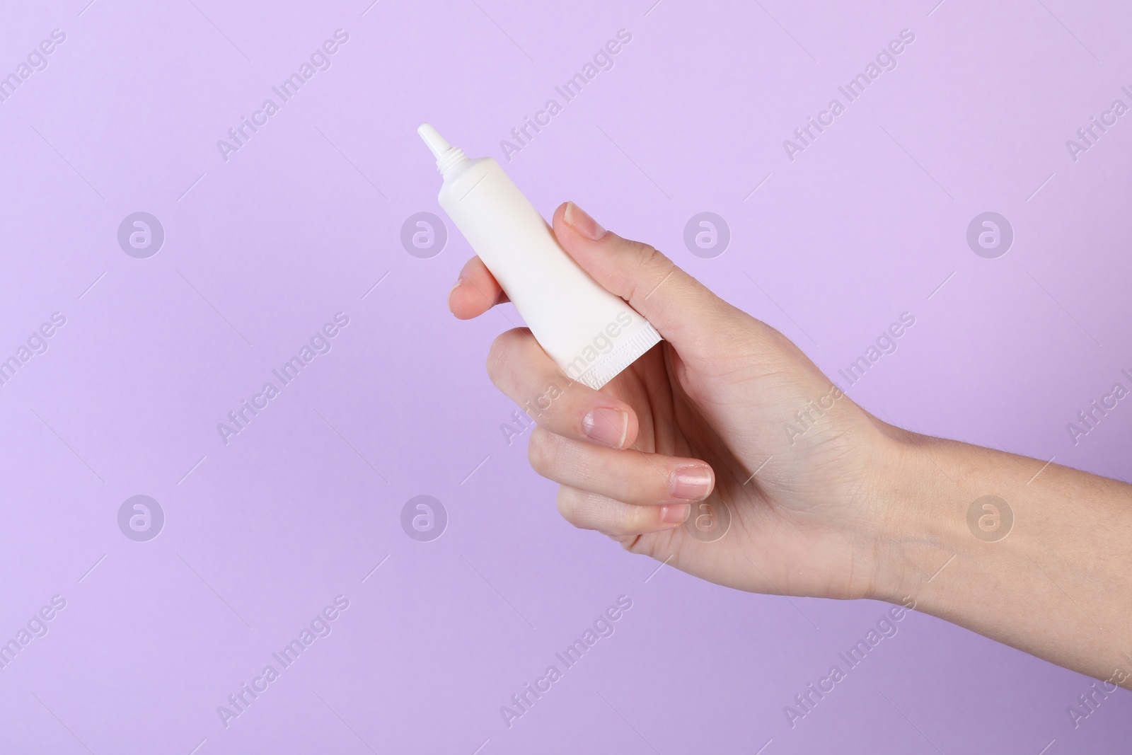 Photo of Woman with lip balm on violet background, closeup