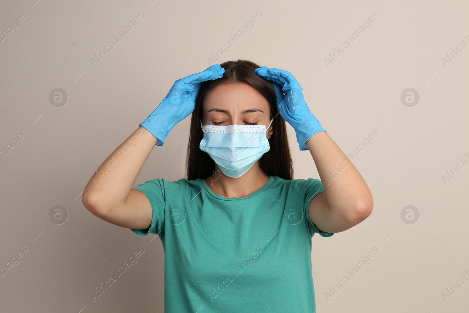 Photo of Stressed woman in protective mask on beige background. Mental health problems during COVID-19 pandemic