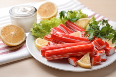 Photo of Delicious crab sticks served on wooden table, closeup