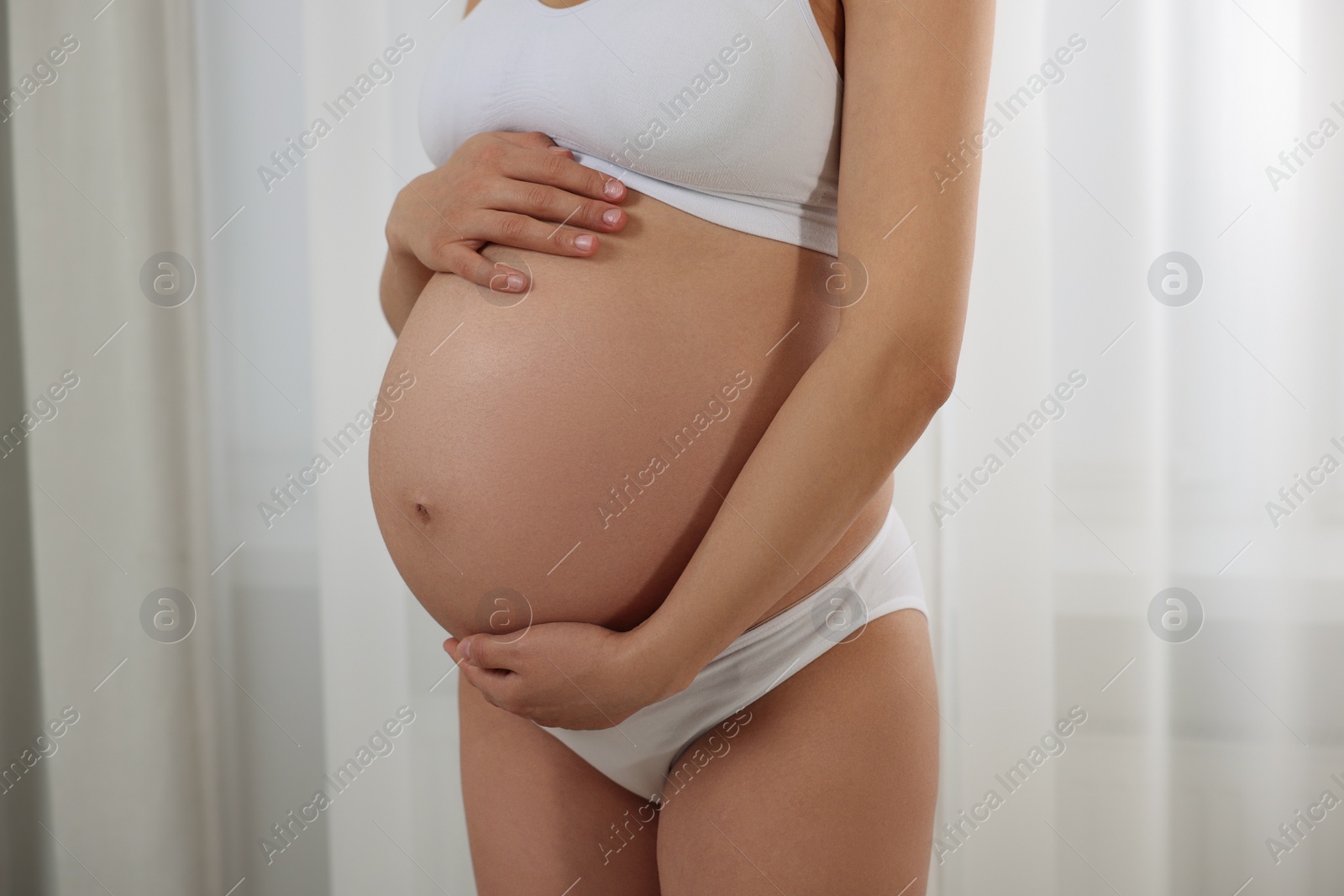 Photo of Pregnant woman in stylish comfortable underwear indoors, closeup