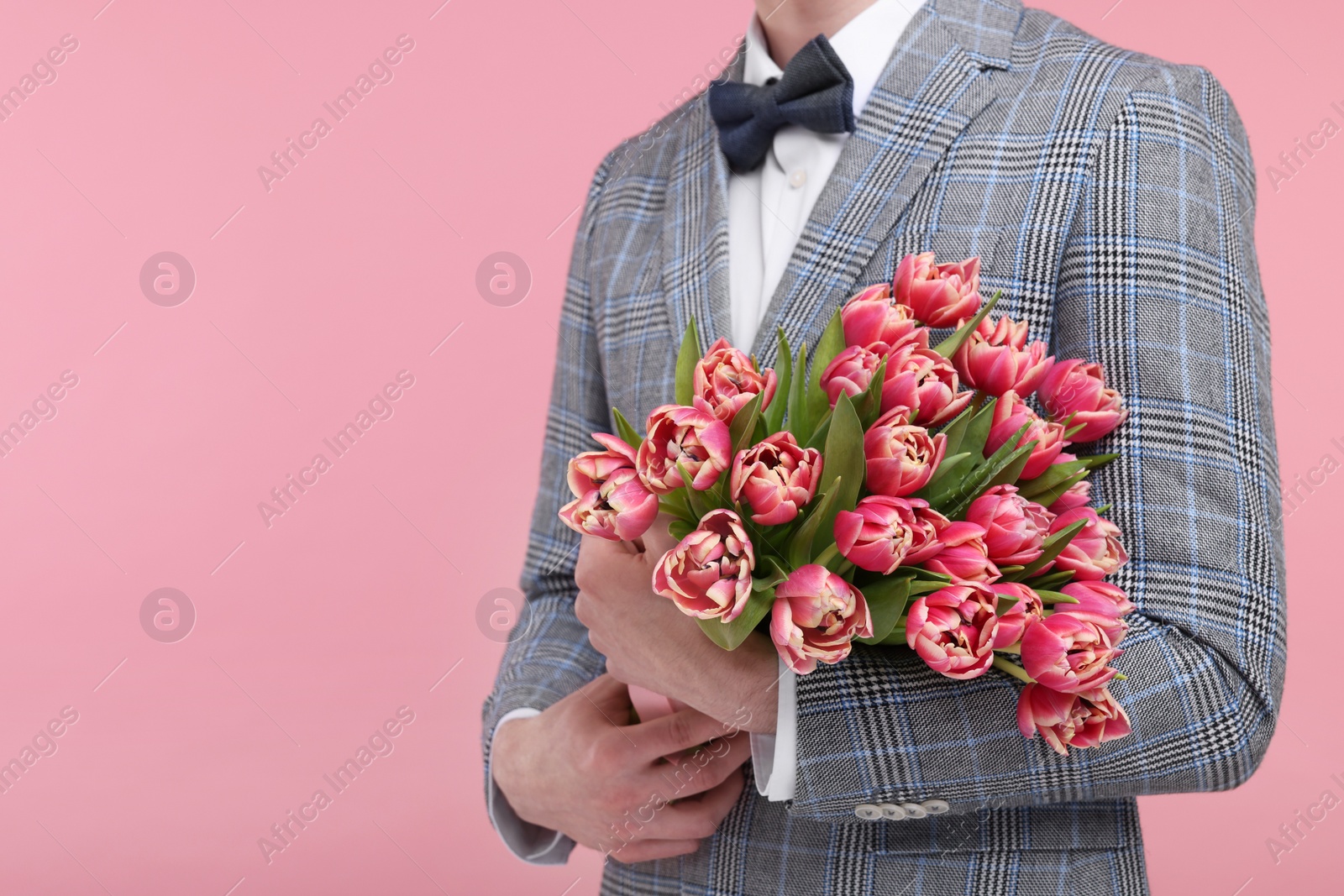 Photo of Man with beautiful bouquet on pink background, closeup. Space for text