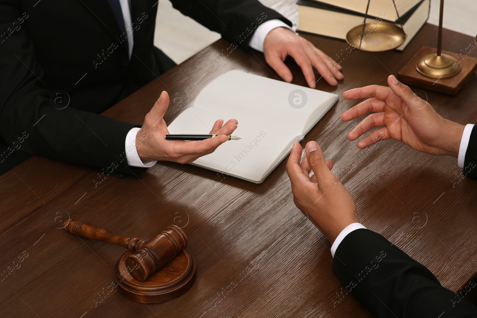 Photo of Law and justice. Lawyers having discussion at wooden table, closeup