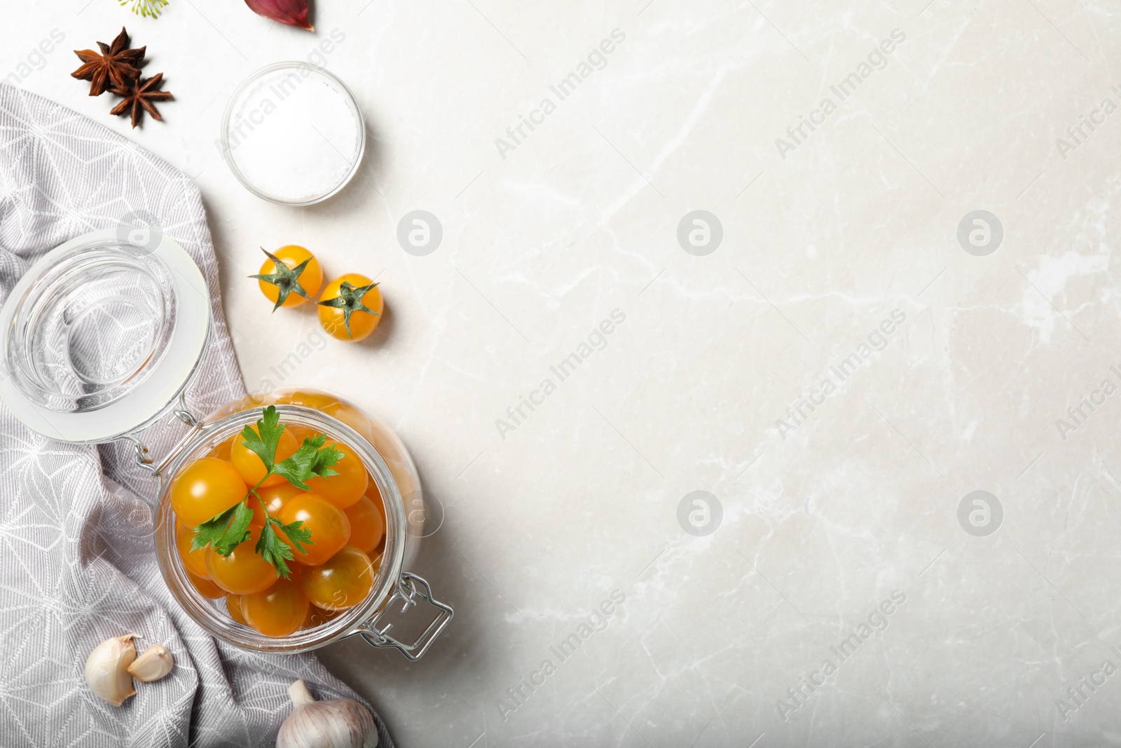 Photo of Pickling jar with fresh yellow tomatoes on light table, flat lay. Space for text