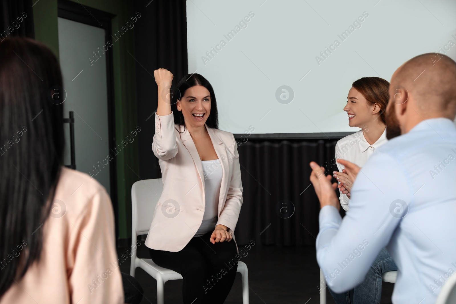 Photo of Business people at seminar in conference room with video projection screen