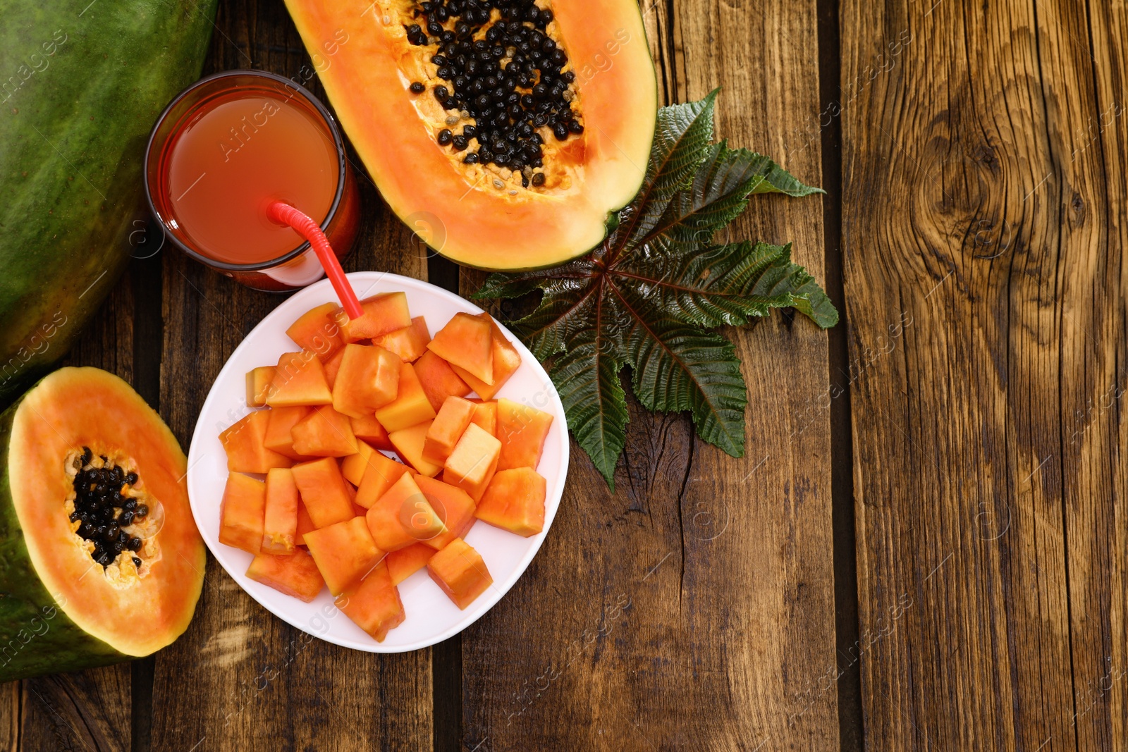 Photo of Flat lay composition with fresh juicy papayas on wooden table, space for text