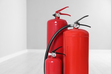 Photo of Fire extinguishers on floor indoors, space for text