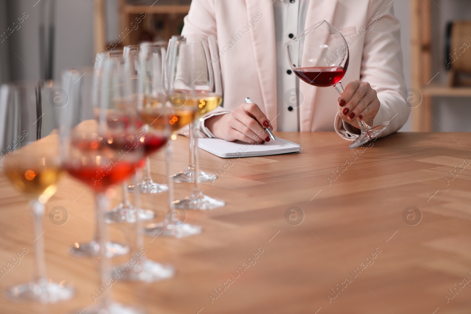 Photo of Sommelier tasting different sorts of wine at table indoors, closeup