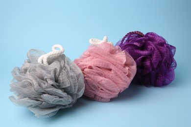 Photo of Colorful shower puffs on light blue background