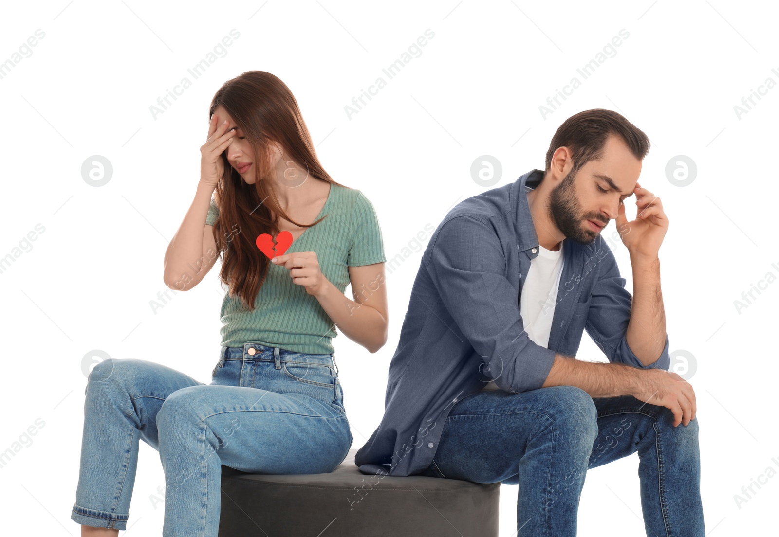 Photo of Woman with torn paper heart near her boyfriend on white background. Relationship problems